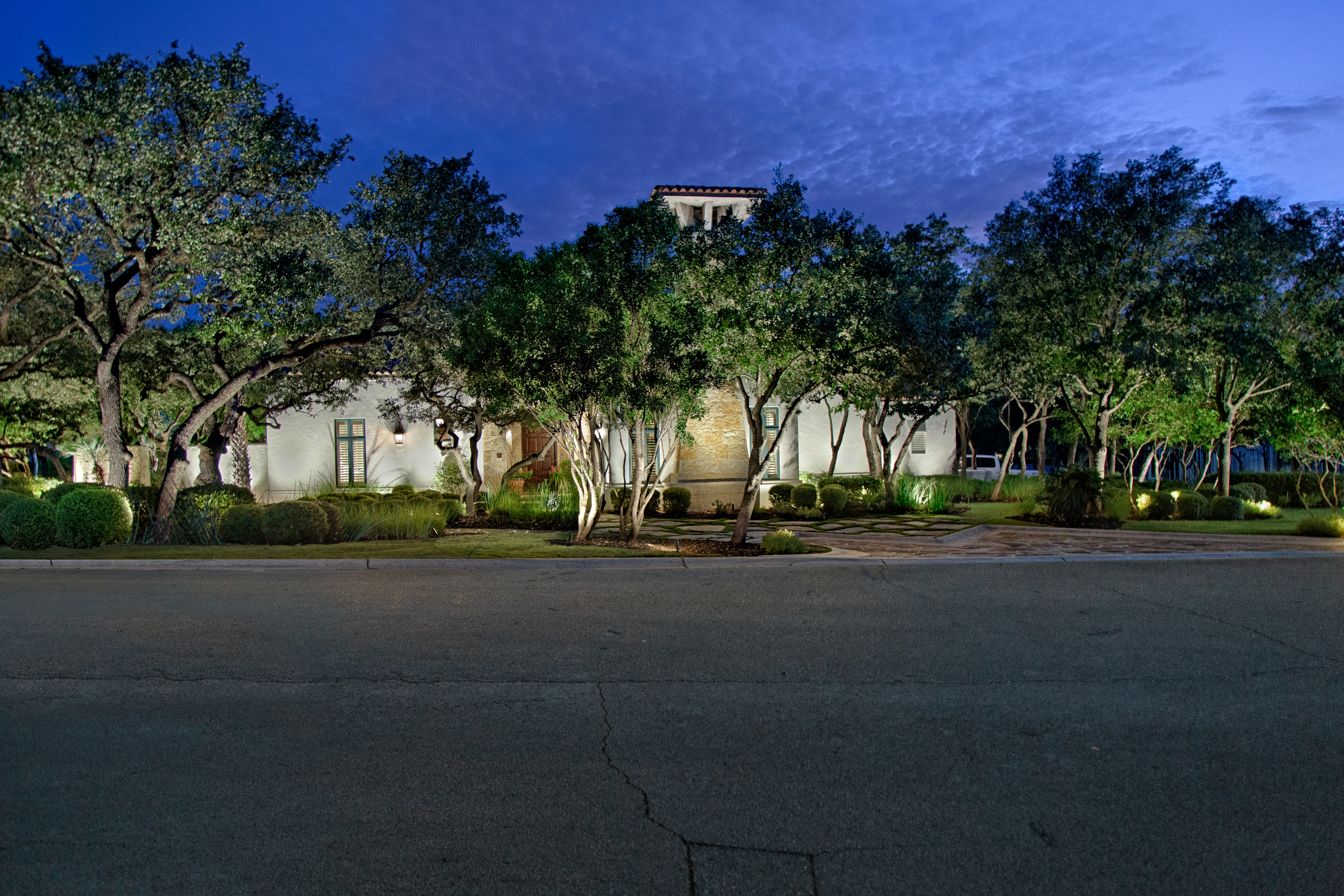 home with trees with outdoor lighting
