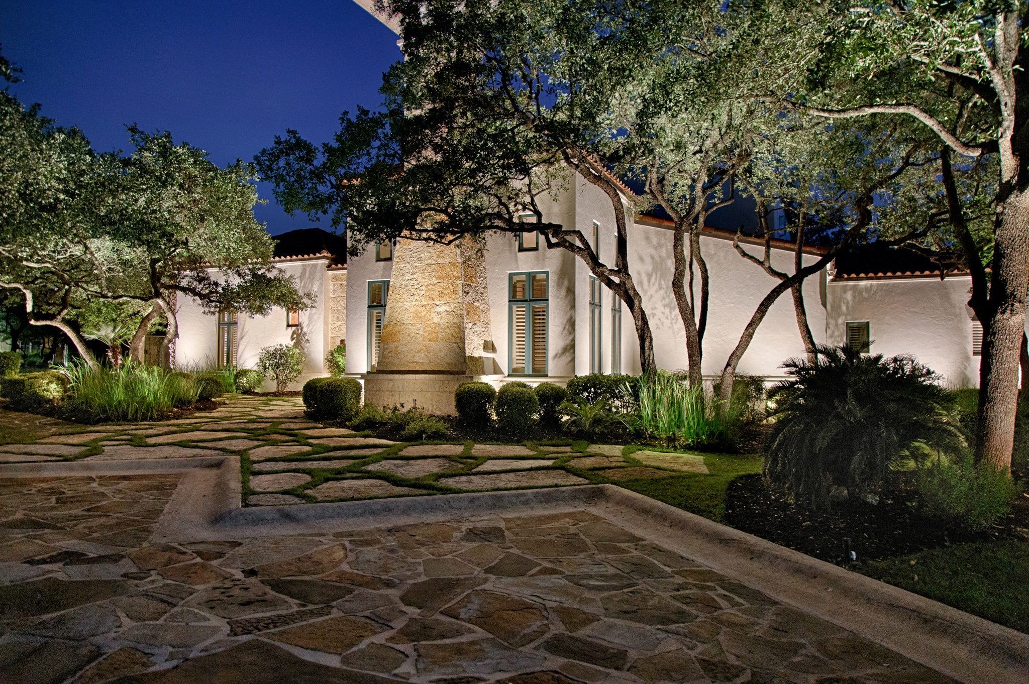 front stone walkway home with outdoor lighting