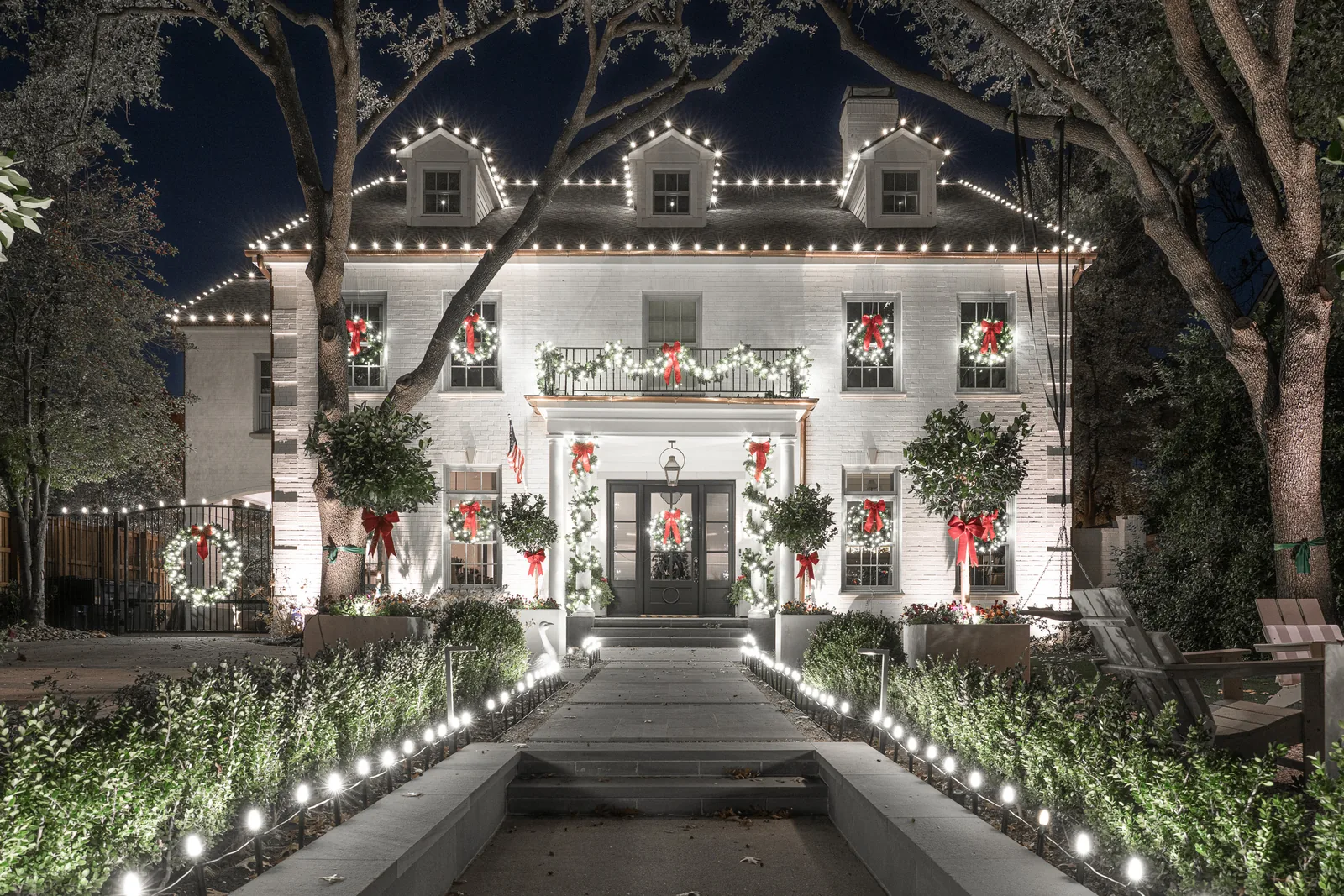 Two-story home in the Lakewood neighborhood with wreaths on every window and a lit pathway leading to the entry, a $6,000 Christmas lighting installation by The Perfect Light
