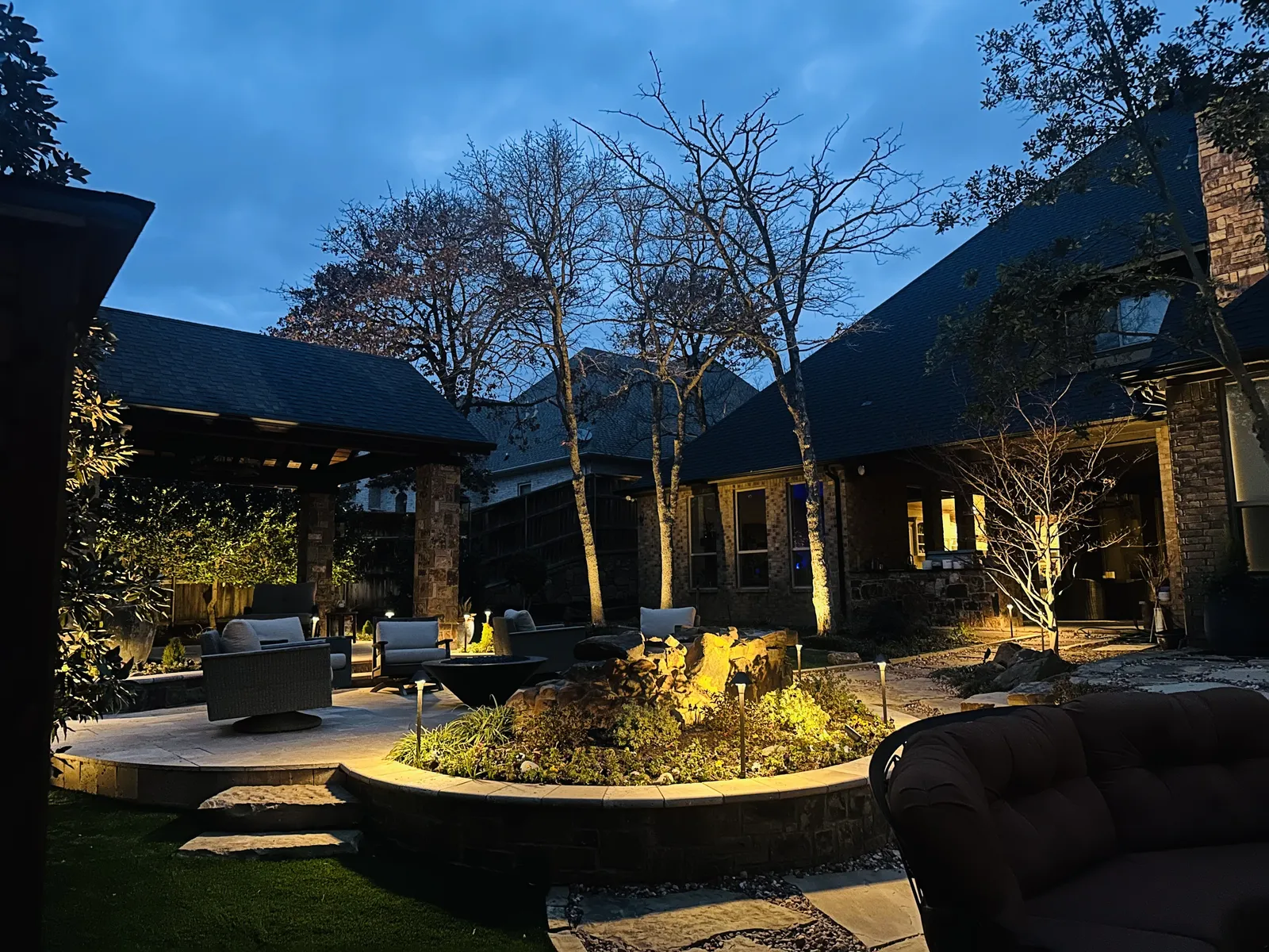 The Perfect Light landscape lighting illuminating a Texas home exterior