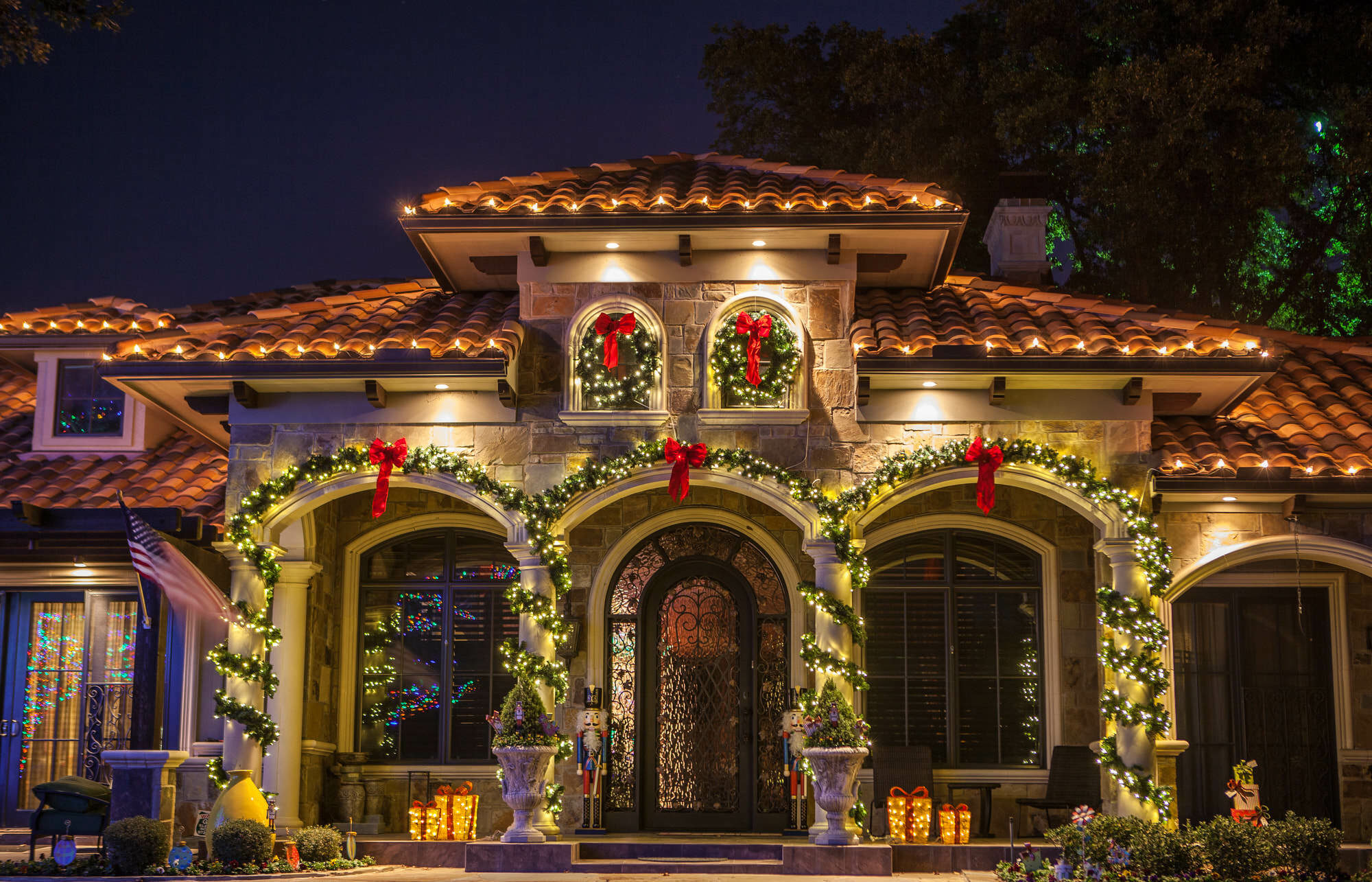 home christmas lights with garlands and decor by The Perfect Light, an Outdoor Lighting Contractor specializing in Christmas Lighting and Landscape Lighting serving the Dallas-Fort Worth, Austin, Houston, and San Antonio Metroplexes.